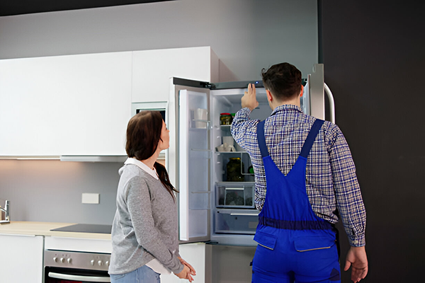 Técnico y cliente feliz revisando nevera
